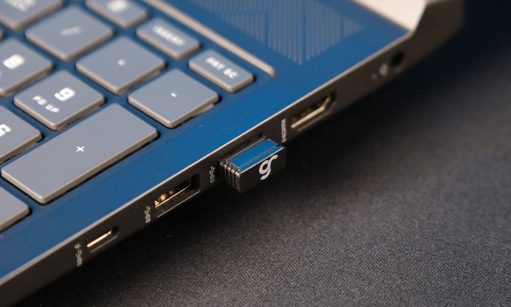 Close-up van de GameRaider M OLED 8K Hz RGB-scherm met draadloze gaming muis op een zwart oppervlak.