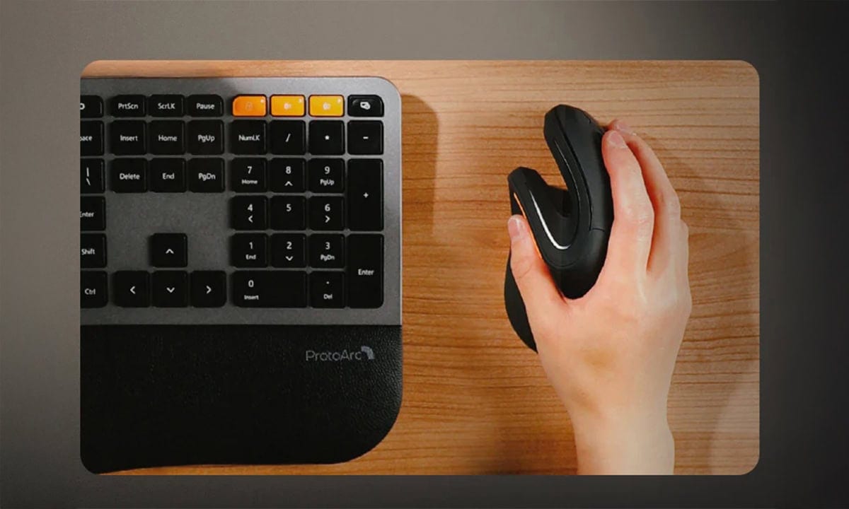 Draadloze ergonomische verticale muis in wit en goud, ontworpen voor comfort en precisie, geplaatst naast een toetsenbord op een houten bureau.