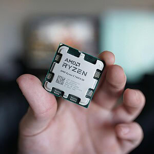 Hand holding an AMD Ryzen CPU processor, showcasing a high-performance computer component for gaming and professional use.