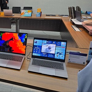 Geavanceerde laptops en technologieën op een beurs, gericht op gaming en grafische prestaties, gepresenteerd op een professionele stand.
