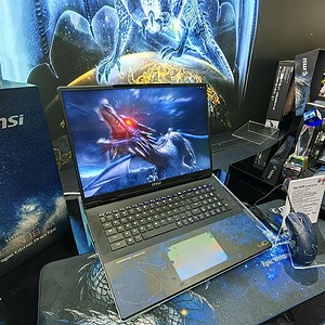 Gaming laptop met drakenbeeld op scherm, gaming accessoires en MSI-producten op tafel, geschikt voor gaming en high-performance gebruik.