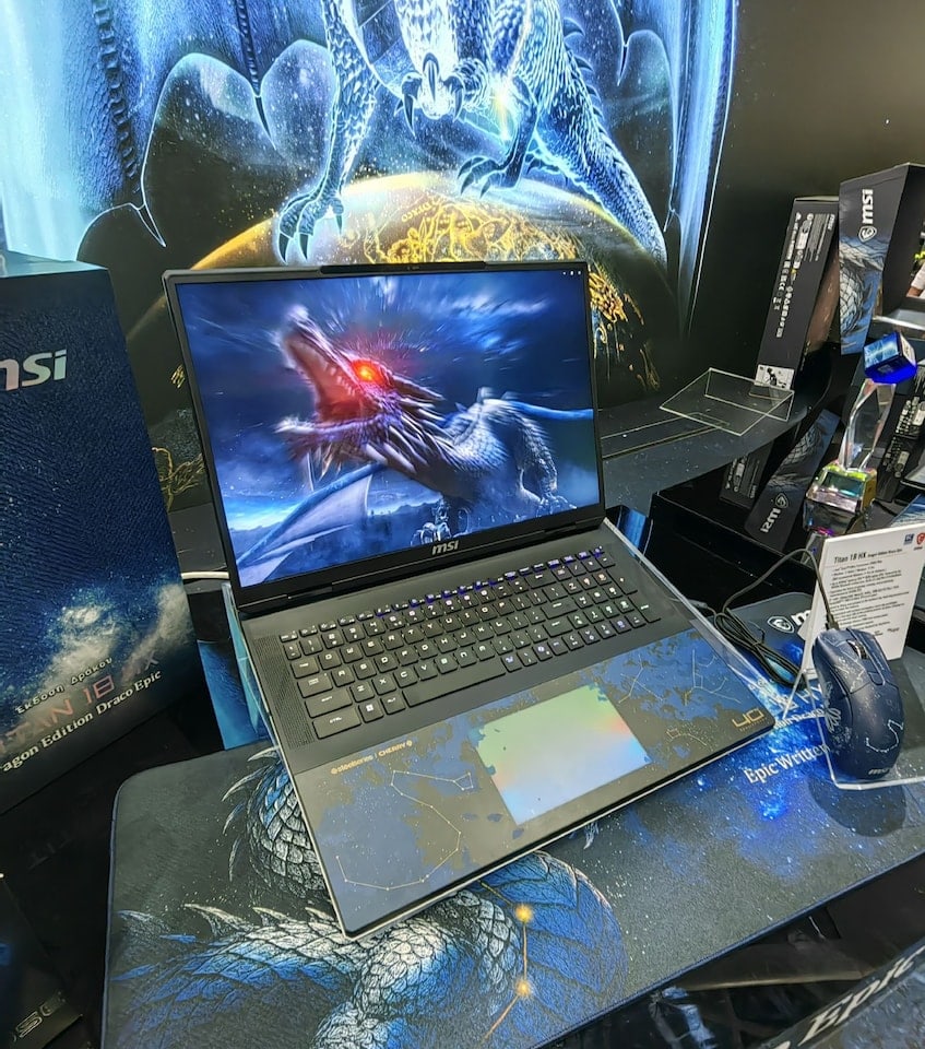 Gaming laptop met drakenbeeld op scherm, gaming accessoires en MSI-producten op tafel, geschikt voor gaming en high-performance gebruik.