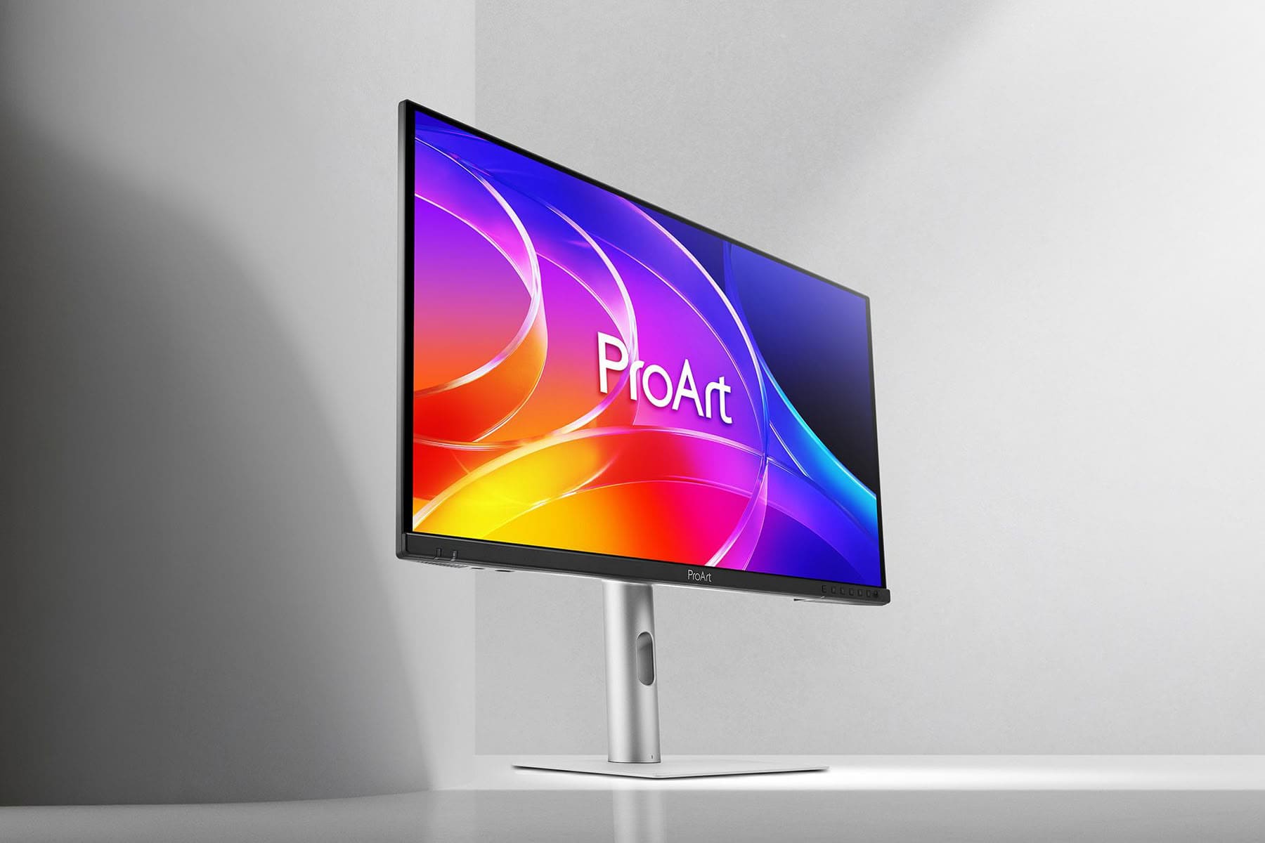 ProArt OLED monitor met kleurrijk scherm en zilveren standaard op bureau.